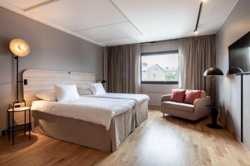 a bedroom with a bed and a chair and a window at Scandic Pohjanhovi in Rovaniemi