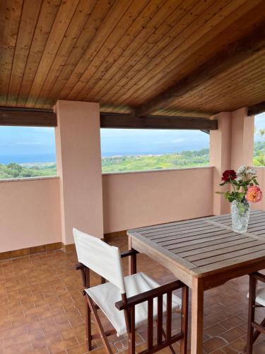 a dining room with a wooden table and white chairs at Villa degli Ulivi in Sciconi