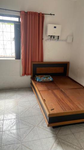 a bedroom with a wooden bed in a room with a window at Apartamento no centro in Jequié