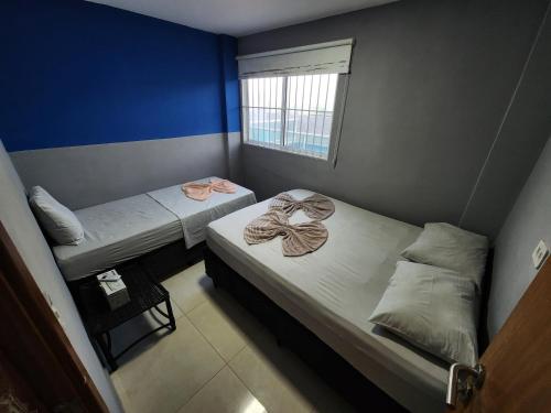 two beds in a small room with a window at Porto de Galinhas Pé na Areia Belize in Porto De Galinhas