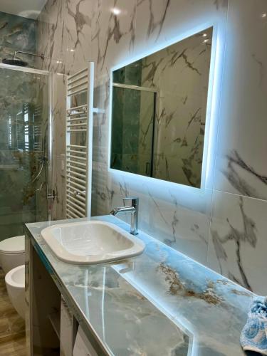 a bathroom with a sink and a mirror at Vista Mare Luxury Rooms & Apartments in Margherita di Savoia
