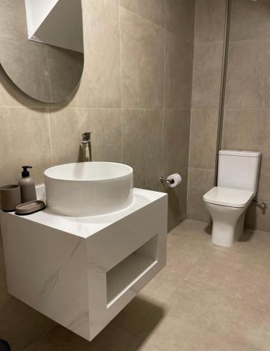 a bathroom with a white sink and a toilet at Villa on the sands in Ureki