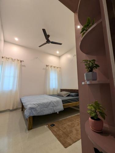 Elite Homes في تشكماغالور: غرفة نوم بها سرير ومروحة سقف