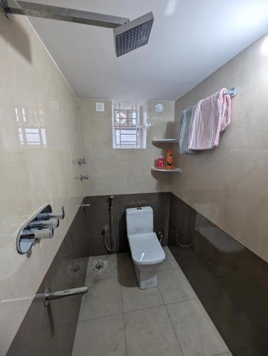 a small bathroom with a toilet and a shower at Elite Homes in Chikmagalūr