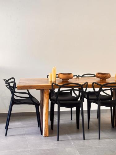 une table en bois entourée de quatre chaises noires dans l'établissement Spacieux T3 Emplacement idéal, à Calvi