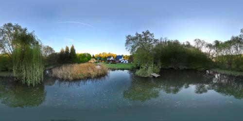 a view of a lake with trees and a house at Ferienhaus am Mittelberg in Nordhausen