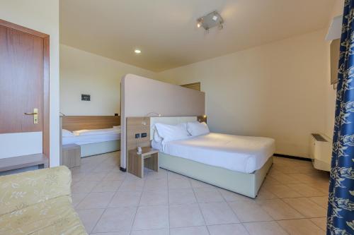 a hotel room with two beds and a couch at Hotel Ristorante Al Fiore in Peschiera del Garda