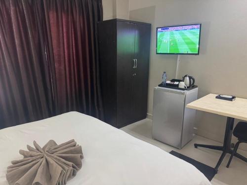 a hotel room with a bed and a television at Milford Lodge in Kitwe