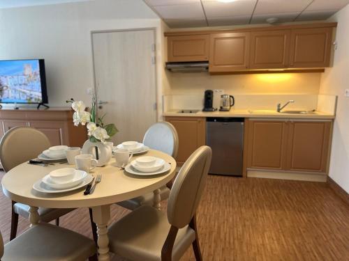 une cuisine avec une table et des chaises ainsi qu'une cuisine avec une table et des chaises dans l'établissement T2 à proximité Grands Buffets, à Narbonne