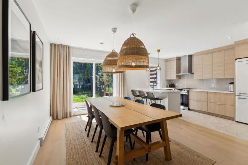 a kitchen and dining room with a wooden table and chairs at Condos Kamik Tremblant by Manitonga in Mont-Tremblant