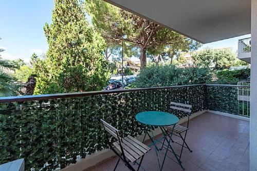 un patio avec une table et des chaises sur un balcon dans l'établissement LE CARDIFF avec grand balcon, piscine et parking, un fabuleux appartement familial en basse Californie, à Cannes