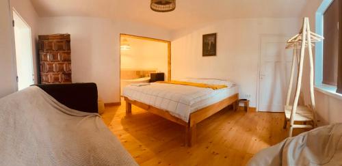 een slaapkamer met een bed en een spiegel bij Menasagi Sit & Dream Cottage 2 in Menasag-Ujfalu