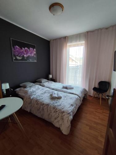 a bedroom with two beds and a table and a window at Penzion Mystery in Vyšné Ružbachy