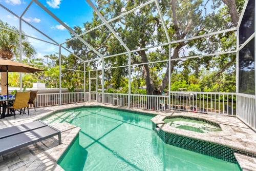 an indoor swimming pool with a glass roof with a table at Villa Champagne - 5322 in Siesta Key