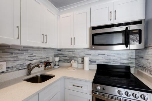 a kitchen with white cabinets and a microwave at Tropical Beach Resorts - Sarasota in Sarasota