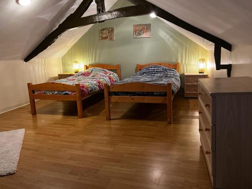 a bedroom with two beds in a attic at La maison Sainte Anne in Tour-en-Bessin