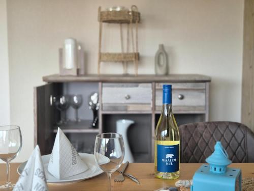 a bottle of wine sitting on a table with glasses at Nordseeblick in Büsum
