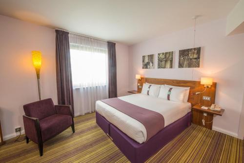 a hotel room with a bed and a chair at Holiday Inn Norwich City by IHG in Norwich