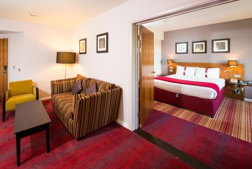 a hotel room with a bed and a couch at Holiday Inn Norwich City by IHG in Norwich
