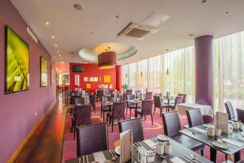 a restaurant with tables and chairs in a room at Holiday Inn Norwich City by IHG in Norwich