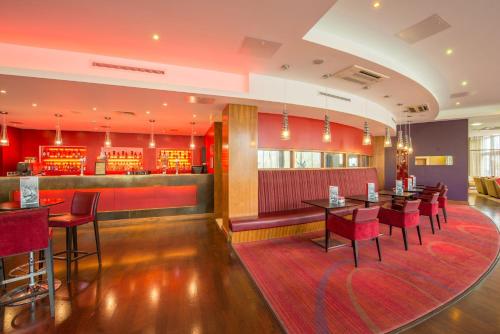 a restaurant with tables and chairs and a bar at Holiday Inn Norwich City by IHG in Norwich