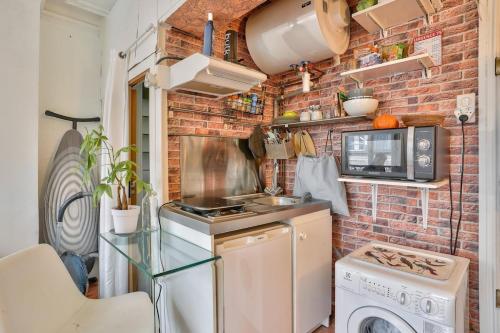 une petite cuisine avec un mur en briques dans l'établissement Arc de Triomphe Studio, à Paris