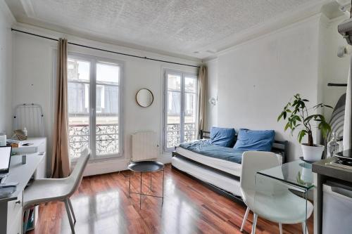 une chambre avec un lit, une table et des chaises dans l'établissement Arc de Triomphe Studio, à Paris