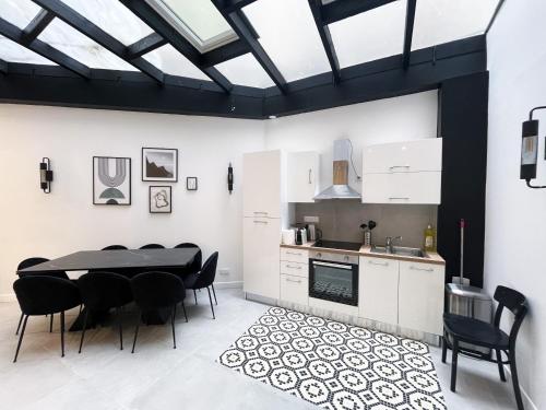 une cuisine et une salle à manger avec une table et des chaises dans l'établissement 08 Design Flat Republique, à Paris