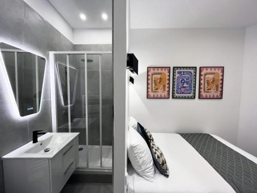 - une chambre avec un lit blanc et un lavabo dans l'établissement 08 Design Flat Republique, à Paris