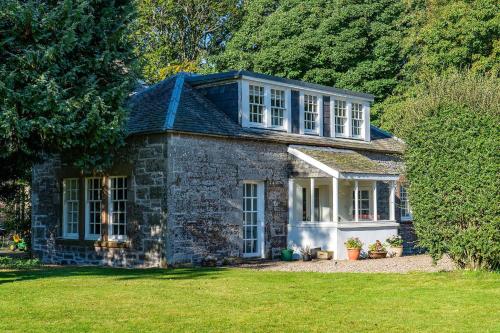 an old stone house in a field of grass at Kirkgate Cottage in Eassie and Nevay