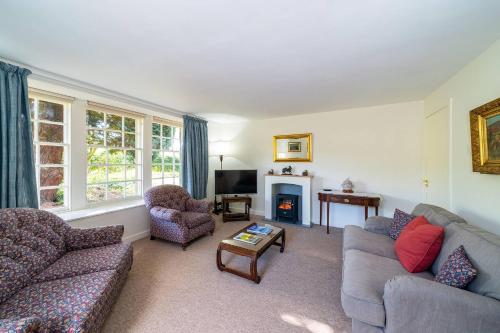 a living room with two couches and a fireplace at Kirkgate Cottage in Eassie and Nevay