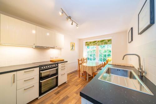 a kitchen with a sink and a counter top at Kirkgate Cottage in Eassie and Nevay