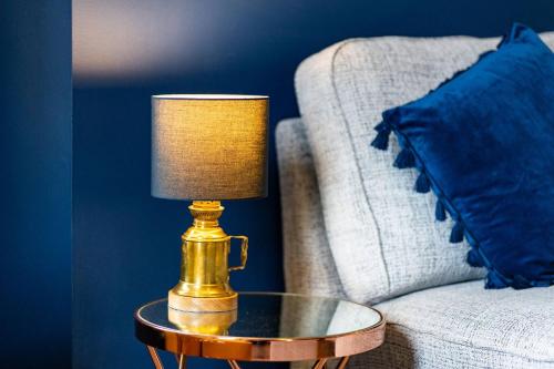 a gold lamp on a table next to a couch at The Tollbooth in Clackmannan