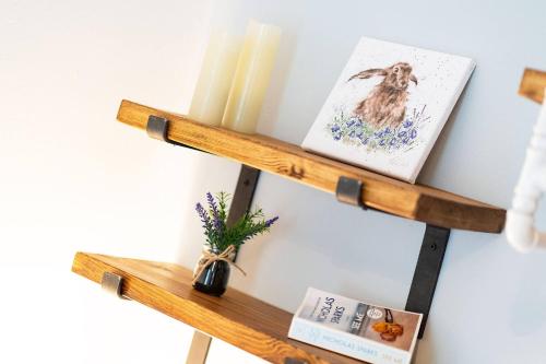 a wooden shelf with two books and a candle at The Tollbooth in Clackmannan