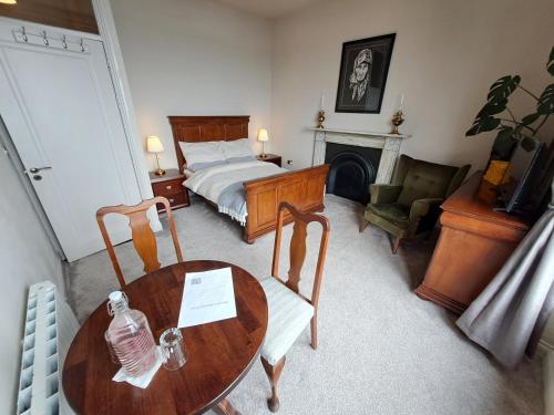 a bedroom with a bed and a table and chairs at Westways House in Cobh