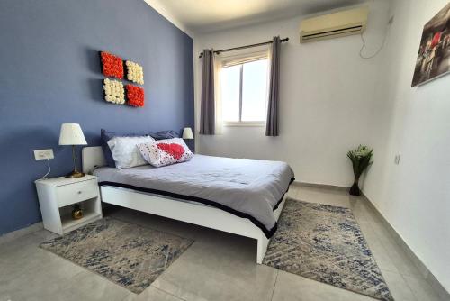 a bedroom with a bed and a window at Lovely three-room apartment above the promenade in Ashdod