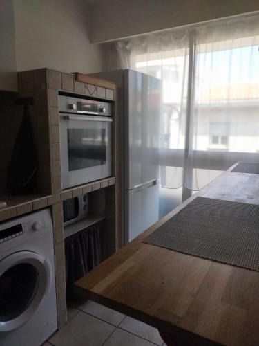 une cuisine avec un lave-linge et un micro-ondes dans l'établissement Grand studio , proche port Bastia, à Bastia