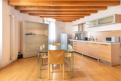 a kitchen with a glass table and some chairs at MAISON MARIA city center Public Parking Available in Vicenza