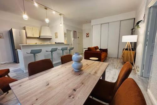un salon avec une table et des chaises en bois dans l'établissement Appartement gare, à Perpignan