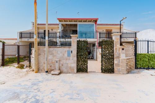 a house with a gate in front of it at Beach House - Salento Selection in Torre rinalda