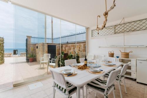 a kitchen and dining room with a table and chairs at Beach House - Salento Selection in Torre rinalda
