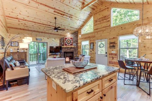 a log cabin kitchen and living room with a table and chairs at 10 Mi to Main St Murphy Cabin with Covered Deck! in Murphy