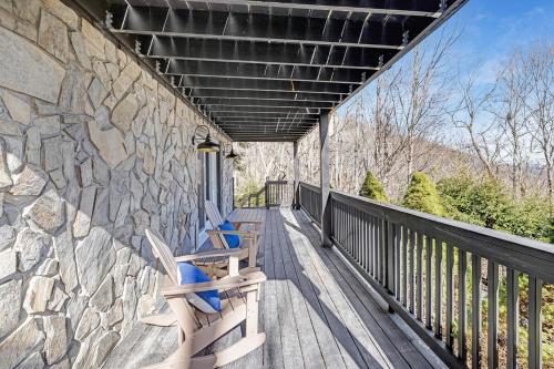 two chairs sitting on a porch with a stone wall at Mtn Views, Game Room, Pet Friendly! in Seven Devils