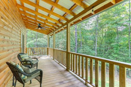 a cabin with two chairs on a wooden porch at 10 Mi to Main St Murphy Cabin with Covered Deck! in Murphy