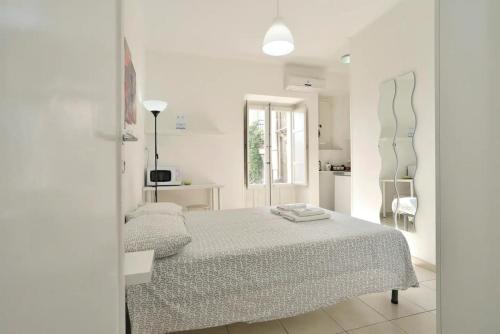 a white bedroom with a bed and a window at L'Altra Modica Locazione Turistica in Modica