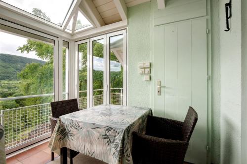 a dining room with a table and chairs on a balcony at Haus Am Sonnenhügel in Bad Urach