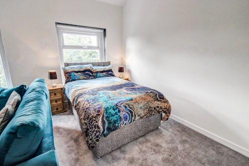 a bedroom with a bed and a couch and a window at Quaint Studio Apartment Near To Waterfront in Wallasey