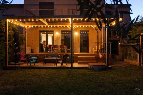 une pergola avec des lumières sur une cour arrière la nuit dans l'établissement Maison, piscine & vue sur la Cité de Carcassonne, à Carcassonne