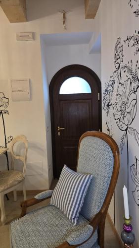 a room with a chair and a door with flowers on the wall at A casa di Matilde in Montegiorgio