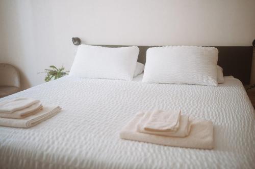 a white bed with two towels on top of it at Borgo Pio Suite Apartment in Rome